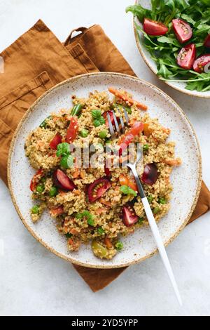 Veganer warmer Salat mit Couscous, Tomaten, grünen Bohnen, Minze, gerösteten Karotten und süßen Paprika. Couscous mit Gemüse drin Stockfoto