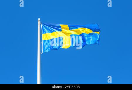 Die Flagge Schwedens, die im Wind gegen einen blauen Himmel fliegt Stockfoto