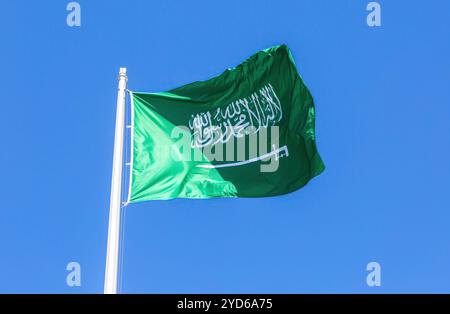 Die Nationalflagge Saudi-Arabiens winkt im Wind vor einem blauen Himmel Stockfoto