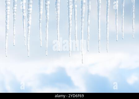 Makroaufnahme des Abschmelzens eines Eiszapfens von einem anderen und echten blauen Himmel Stockfoto