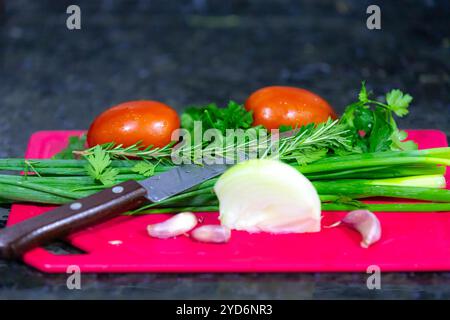 Klassische Kombination von Gemüse zum Kochen, Knoblauch, Zwiebeln, Tomaten, Petersilie, Schnittlauch und Rosmarin Stockfoto