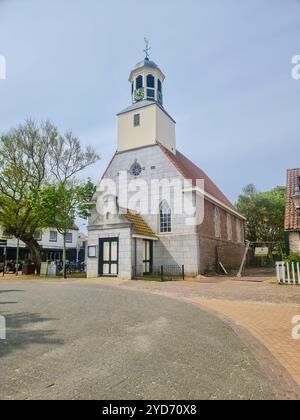 Eine majestätische Kirche mit einem Uhrenturm steht hoch und stolz im Herzen von Texel, umgeben von der geschäftigen Aktivität des Schlepptagens Stockfoto