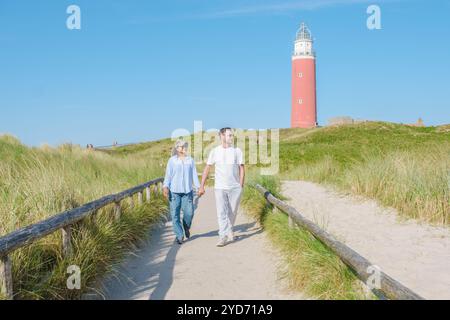 Ein paar gemütliche Spaziergänge entlang eines malerischen Pfades in der Nähe des Texel Lighthouse, genießen die atemberaubende Aussicht auf die Küste und das Geräusch von C Stockfoto