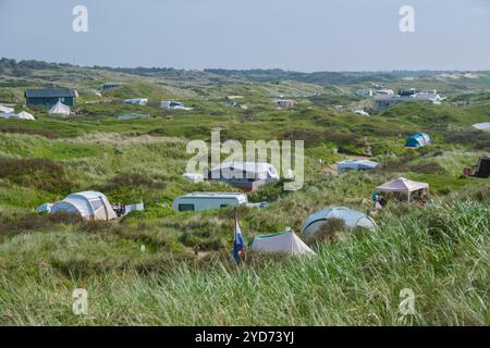 Eine Gruppe von Zelten auf einem üppigen, grasbewachsenen Hügel auf der malerischen Insel Texel in den Niederlanden bietet eine friedliche und friedliche Atmosphäre Stockfoto