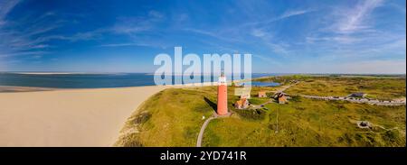 Majestätischer Leuchtturm, der über dem Sandstrand thront, mit Wellen, die sanft an der Küste zusammenbrechen, bietet Führung und Sicherheit beim Passieren Stockfoto