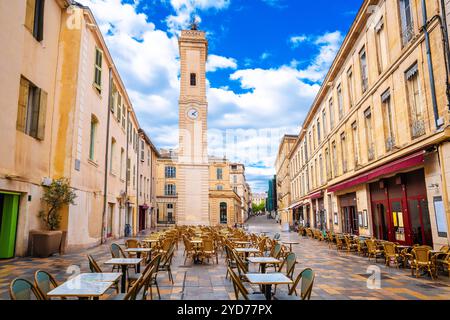 Restaurantstraße in Nimes und Blick auf den Kirchturm, Südfrankreich, die Präfektur des Départements Gard in der Region Occitanie Stockfoto