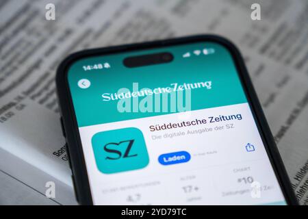 Bayern, Deutschland - 25. Oktober 2024: IPhone mit der App Süddeutsche Zeitung SZ im Appstore auf einer Zeitung. Symbolbild Einstellung lokaler Druckausgaben und Schließung lokaler Redaktionen *** iPhone mit der App Süddeutsche Zeitung SZ im Appstore auf einer Zeitung. Symbolbild Einstellung der lokalen Printausgaben und schließung der Lokalredaktionen Stockfoto