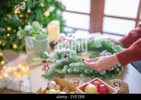 Frau, die Mistelkranz macht Weihnachtskranz Dekoration mit handgemachten DIY Winter Grün Blumenhändler Hände machen Weihnachtswrea Stockfoto