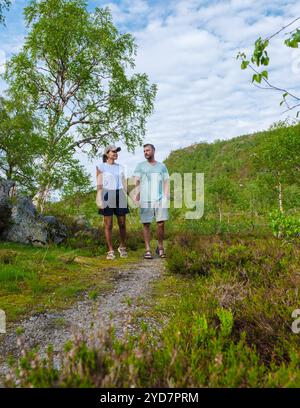 Ein paar Spaziergänge Hand in Hand auf einem Pfad in einem norwegischen Wald, genießen die frische Luft und die natürliche Schönheit der Umgebung Stockfoto