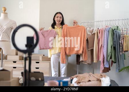 Young Asian girlÂ Online-Beratung mit Stylist Designer Online-Videokurs oder Schulung von stilvoller Kleidung an Kleiderbügeln c Stockfoto