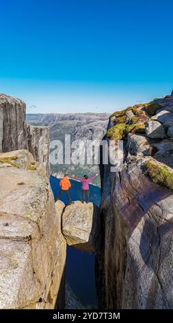 Zwei Menschen stehen am Rande von Kjeragbolten, einer berühmten Klippe in Norwegen Stockfoto