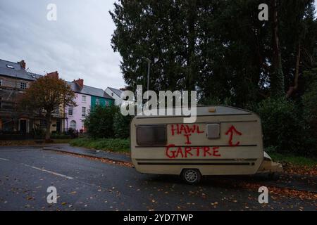 Carmarthen, Großbritannien. 25. Oktober 2024. Eine Karawane wird vor den walisischen Regierungsbüros in Carmarthen verlassen, die mit Graffiti befüllt ist, die die Menschen zum Recht auf Wohnung auffordern, nachdem die walisische Regierung vermeintlich nicht aktiv war. Gruffydd Thomas/Alamy Stockfoto