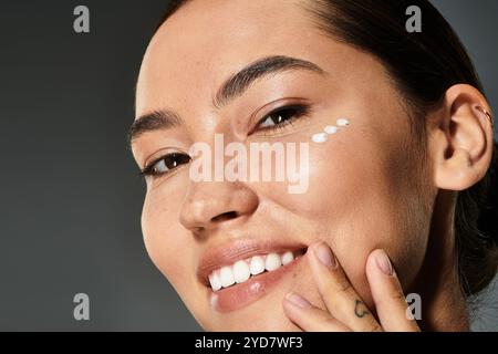 Eine freudige Frau verschönert ihre natürliche Schönheit und wendet gleichzeitig Hautpflege in einer stilvollen Umgebung an. Stockfoto
