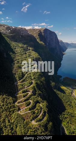 Ein Blick aus der Vogelperspektive auf eine gewundene Straße, die sich durch einen üppigen Berg in Norwegen schlängelt. Lysebotn, Lysefjord Stockfoto