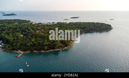 Porec, Istrien, Kroatien - 26. August 2024: Luftaufnahme der malerischen Küste von Istrien, mit der Stadt Porec in Kroatien, umgeben von Inseln und dem tiefblauen Wasser der Adria *** Luftaufnahme der malerischen Küste von Istrien, mit der Stadt Porec in Kroatien, umgeben von Inseln und dem tiefblauen Wasser der Adria Stockfoto