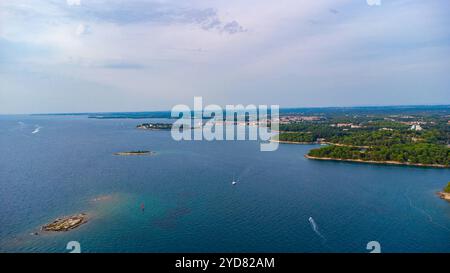 Porec, Istrien, Kroatien - 26. August 2024: Luftaufnahme der malerischen Küste von Istrien, mit der Stadt Porec in Kroatien, umgeben von Inseln und dem tiefblauen Wasser der Adria *** Luftaufnahme der malerischen Küste von Istrien, mit der Stadt Porec in Kroatien, umgeben von Inseln und dem tiefblauen Wasser der Adria Stockfoto