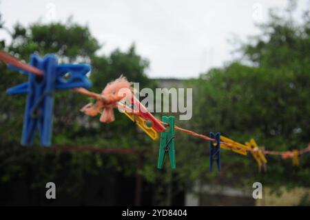 Farbenfrohe Kleiderschränke auf einer Linie vor grünem Hintergrund an einem bewölkten Tag Stockfoto