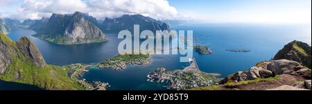 Ein Panoramablick auf einen atemberaubenden norwegischen Fjord, der die dramatische Küste, üppiges Grün und ferne Inseln zeigt. Reinebringen, Lofoten, Norwegen Stockfoto