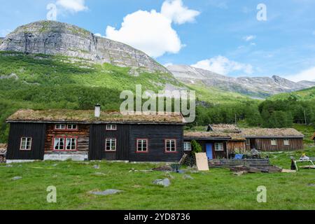 Eine traditionelle norwegische Hütte mit einem Grasdach liegt inmitten einer üppigen grünen Berglandschaft. Innerdalen Valley Norwegen Stockfoto