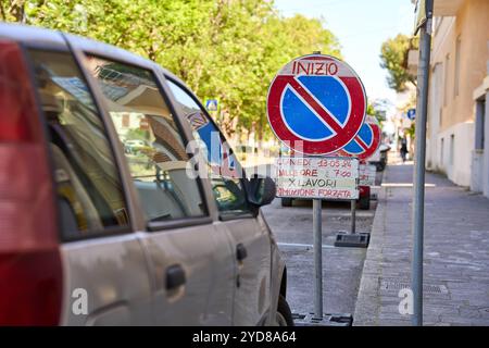 Ancona, Italien - 10. Mai 2024: Ein Auto parkt in Italien in einem Parkverbot, gekennzeichnet durch ein Verkehrsschild mit dem Hinweis auf Bauarbeiten und eine drohende Zwangsentfernung *** ein Auto parkt in Italien in einem Parkverbot, gekennzeichnet durch ein Verkehrsschild mit dem Hinweis auf Bauarbeiten und einer drohenden Zwangsentfernung Stockfoto