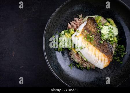 Gebratenes Kabeljaufilet mit Avocadocreme und gekochtem Reis diente als Draufsicht auf nordischem Design-Teller mit Kopierraum Stockfoto