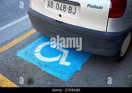 Ancona, Italien - 10. Mai 2024: Ein Auto parkt in Italien auf einem Behindertenparkplatz, der durch blaue Markierungen und das Rollstuhlsymbol gekennzeichnet ist *** ein Auto parkt in Italien auf einem Behindertenparkplatz, der durch blaue Markierungen und das Rollstuhlsymbol gekennzeichnet ist Stockfoto