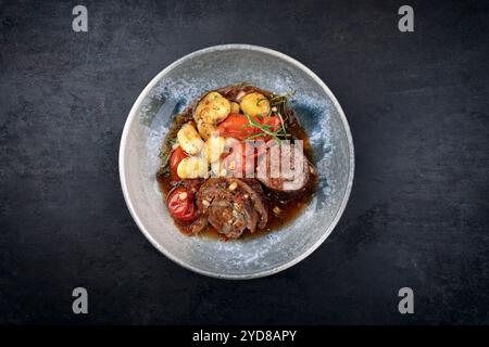 Traditionelle langsam gekochte deutsche Wagyu-Rindfleischrouladen mit Gemüse und Gnocchi serviert in scharfer Rotweinsauce als Blick von oben in A No Stockfoto