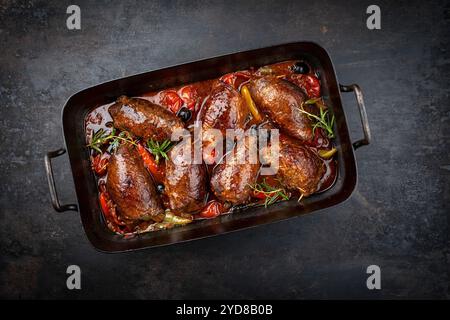 Traditionelle langsam gekochte deutsche Wagyu-Rindfleischrouladen mit Gemüse und Oliven serviert in scharfer Rotweinsauce als Blick von oben in einem rus Stockfoto