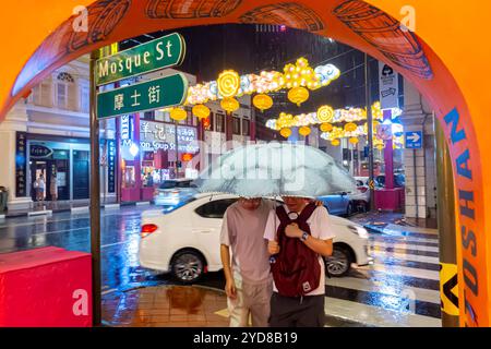 Straßenschild der Moschee, Singapur Chinatown, Regen bei Nacht, Mann und Frau unter Schirm Stockfoto