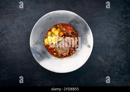 Traditionelle langsam gekochte deutsche Wagyu-Rinderrouladen mit Gemüse und Gnocchi serviert in scharfer Rotweinsauce als Nahaufnahme in A No Stockfoto