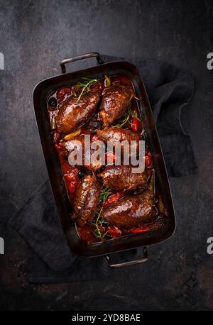 Traditionelle langsam gekochte deutsche Wagyu-Rindfleischrouladen mit Gemüse und Oliven serviert in scharfer Rotweinsauce als Blick von oben in einem rus Stockfoto