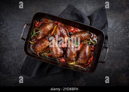 Traditionelle langsam gekochte deutsche Wagyu-Rindfleischrouladen mit Gemüse und Oliven serviert in scharfer Rotweinsauce als Blick von oben in einem rus Stockfoto