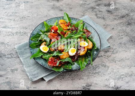 Traditioneller Südtiroler Löwenzahnsalat mit Speck Stockfoto