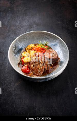 Traditionelle langsam gekochte deutsche Wagyu-Rinderrouladen mit Gemüse und Gnocchi serviert in scharfer Rotweinsauce als Nahaufnahme in A No Stockfoto