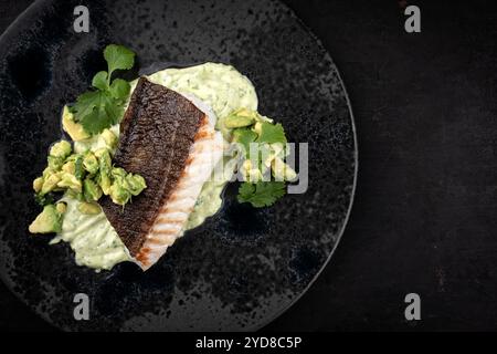 Gebratenes Kabeljaufilet mit Kartoffelpüree und Avocado diente als Draufsicht auf nordischem Design-Teller mit Kopierraum rechts Stockfoto