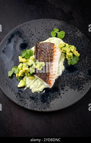 Gebratenes Kabeljaufilet mit Kartoffelpüree und Avocado wurde als Nahaufnahme auf nordischem Design-Teller mit Kopierraum serviert Stockfoto