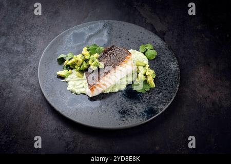 Gebratenes Kabeljaufilet mit Kartoffelpüree und Avocado wurde als Nahaufnahme auf nordischem Design-Teller mit Kopierraum serviert Stockfoto