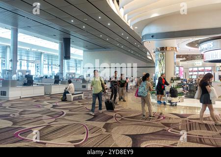 Passagiere gehen nach der Sicherheitskontrolle des Handgepäcks vor dem Eingang des Gates, Singapore Changi Airport, Duty-Free-Shop Stockfoto