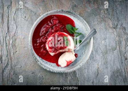 Traditionelles Quark-Mousse mit Rhabarber und Himbeerkompott diente als Blick von oben auf einem nordischen Design-Teller Stockfoto