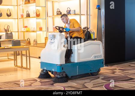 Ein Arbeiter auf Tennant 6100 Sub-Compact Kehrmaschine, der Teppiche am Flughafen Singapur Changi reinigt Stockfoto