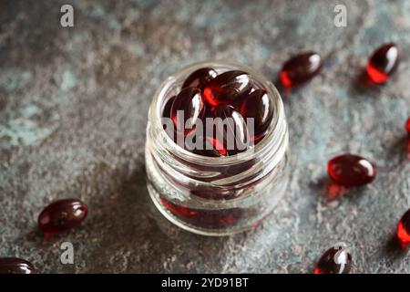 Rote Krillölpillen oder Kugeln in einem Glas, Großaufnahme Stockfoto