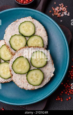 Köstliches vegetarisches Sandwich mit gegrilltem Toast, Frischkäse, Gurken und Samen Stockfoto