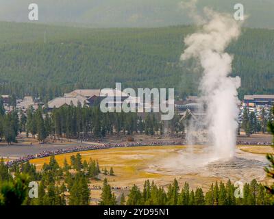 Old Faithful Geysir bricht aus und Old Faithful Inn Lodge vom Aussichtspunkt aus Stockfoto