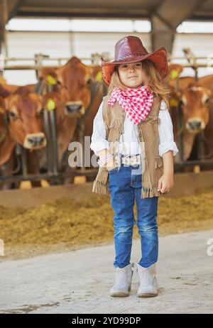 Charmantes Kind im Cowboykostüm auf einer Kuhfarm in Dänemark Stockfoto