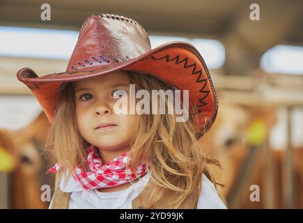 Charmantes Kind im Cowboykostüm auf einer Kuhfarm in Dänemark Stockfoto