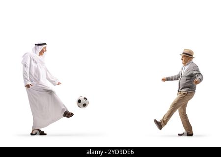 Traditioneller arabischer Mann in ethnischer Kleidung, der mit einem älteren Mann auf weißem Hintergrund Fußball spielt Stockfoto