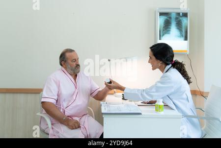 Eine Ärztin untersucht die Krankheit und gibt Ratschläge zur Einnahme von Medikamenten. Für ältere Patienten, die behandelt werden Stockfoto