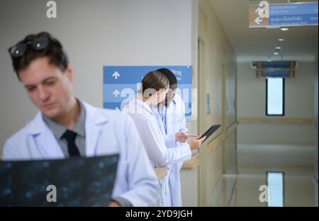 Medizinlehrer und Praktikanten zur Analyse der Röntgenergebnisse des Gehirns des Patienten. Vor grosser Operation im OP Stockfoto
