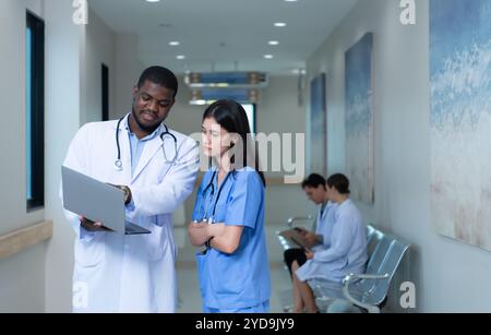 Beide Ärzte analysieren die MRT-Ergebnisse des Patienten auf einem Tablet, um Ideen auszutauschen und neue Informationen für den Patienten zu finden Stockfoto