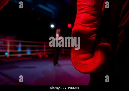 Eine Nahaufnahme eines verwitterten Boxhandschuhs in der Ecke eines Rings, der die Erwartung und den Grimm eines wartenden Käufers symbolisiert. Stockfoto